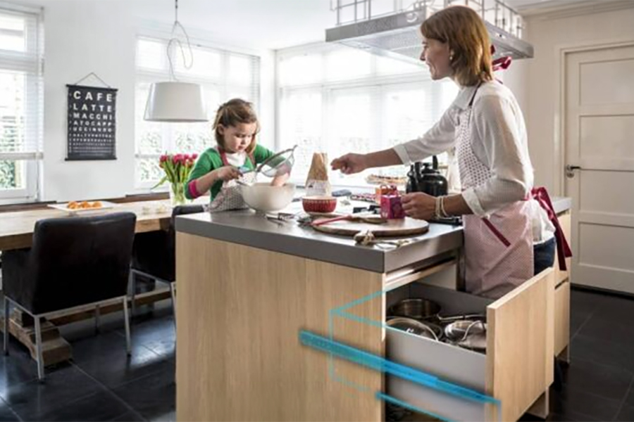 femme et enfant dans la cuisine ouvrent le tiroir