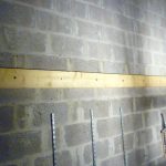 Construction d'un plancher en bois : la poutre fixée au mur