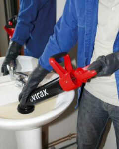 plombier utilise une pompe professionnelle pour déboucher l'évier