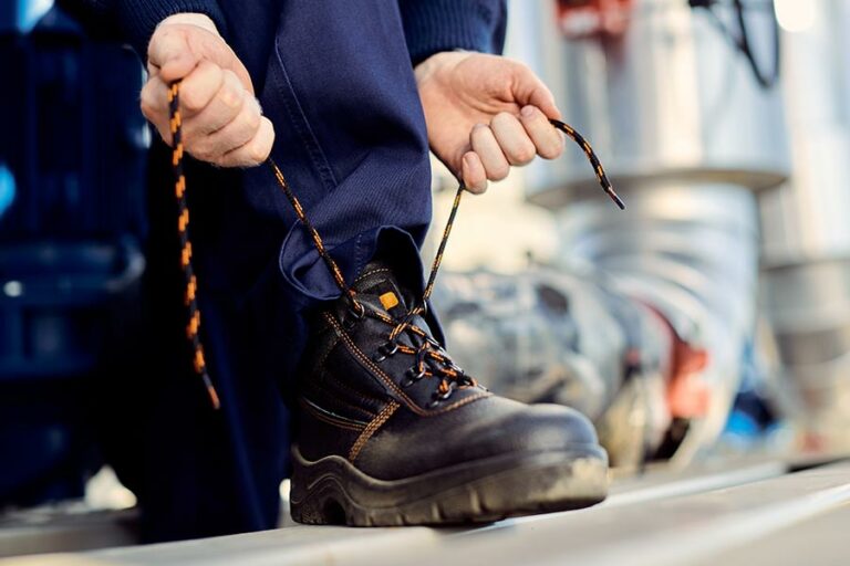 bricoleur lace ses chaussures de sécurité