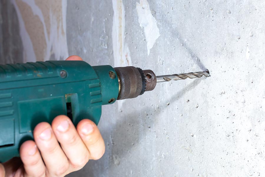 perforateur perce un mur de béton