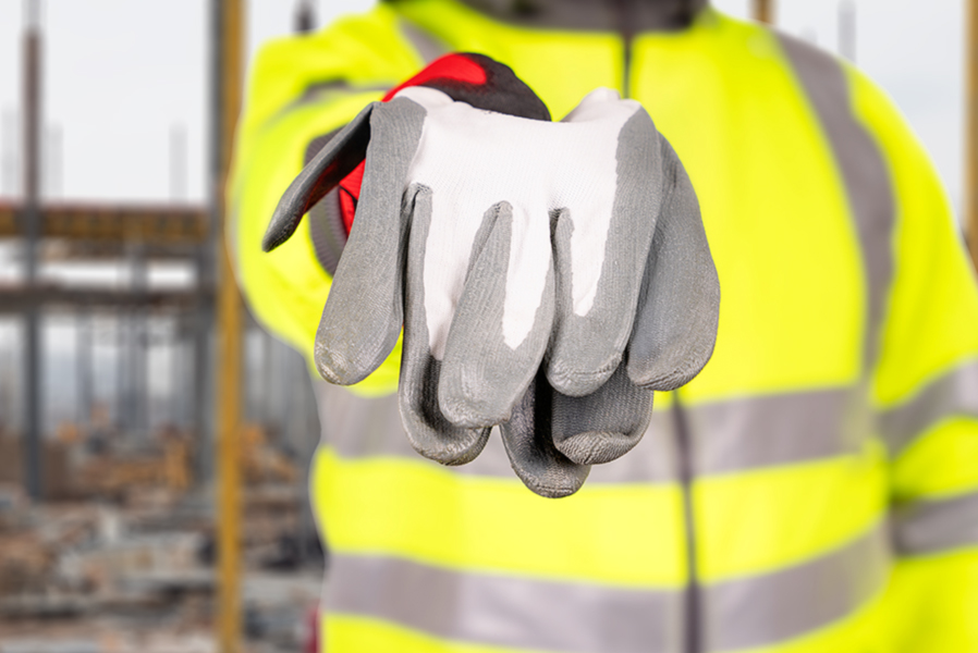 ouvrier du chantier rend ses gants après avoir fini son travail