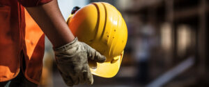 ouvrier tient son casque de sécurité sur un chantier de construction