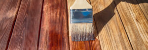 brosse recouvrant surface planche bois avec du vernis ou de la lasure