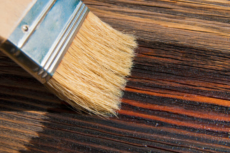 brosse pinceau recouvre une planche sèche avec de l'huile ou lasure, revêtement protecteur pour le bois