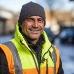 homme ouvrier souriant travaillant en extérieur EPI veste et bonnet