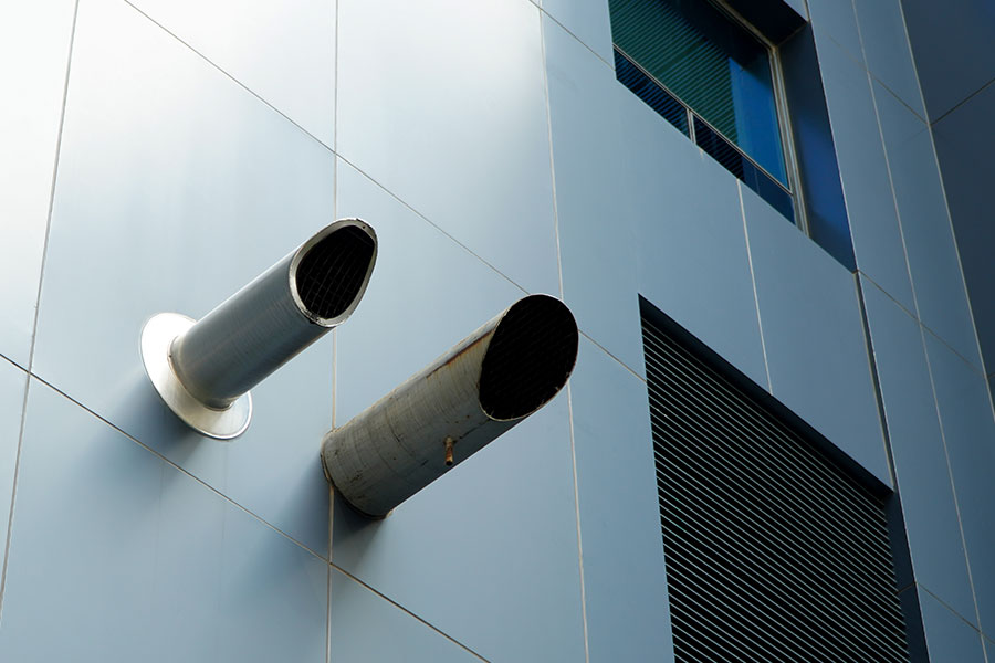 conduit d'extraction de VMC individuelle sur une façade d'immeuble