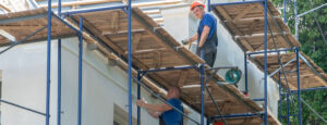 constructeurs debout échafaudages sont engagés dans réparation façade bâtiment plâtre peinture façade maison