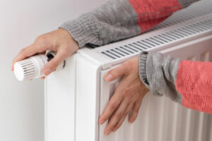 femme touche radiateur froid appareil chauffage domestique augmente puissance