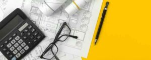 plans calculatrice lunettes et stylo matériel architecte pour conception construction maison aux normes