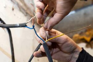 électricien connecte des fils électriques en les nouant