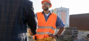 ouvrier sur un chantier de construction serre la main du patron en costume