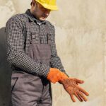 ouvrier enfile des gants de travail pour faire des travaux de rénovation