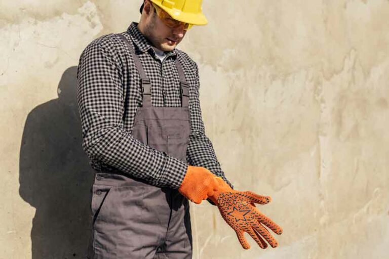 ouvrier enfile des gants de travail pour faire des travaux de rénovation