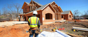 ouvrier du bâtiment devant un chantier de construction de maison