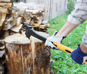 bûcheron aux mains gantées tient une hâche pour couper souche de bois pour stocker bois de chauffage