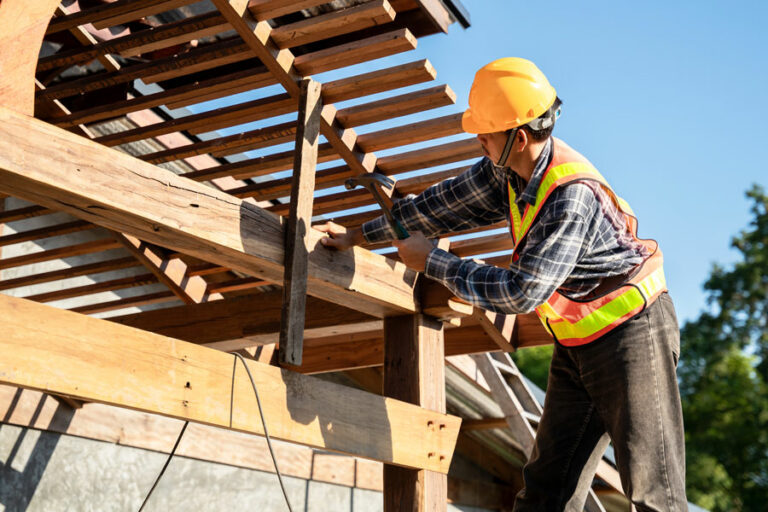 charpentier travaille sur le toit de la maison avec outillage et équipement de protection adaptés