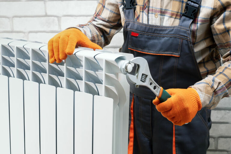 technicien maintenance radiateur eau chaude entretien désembouage avec clé à molette