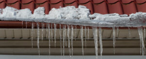 lors du dégel, la neige et les stalactites pendant du toit fondent et gouttent au sol