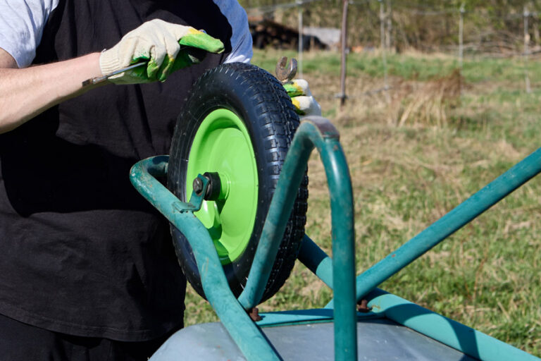 bricoleur change la roue de la brouette