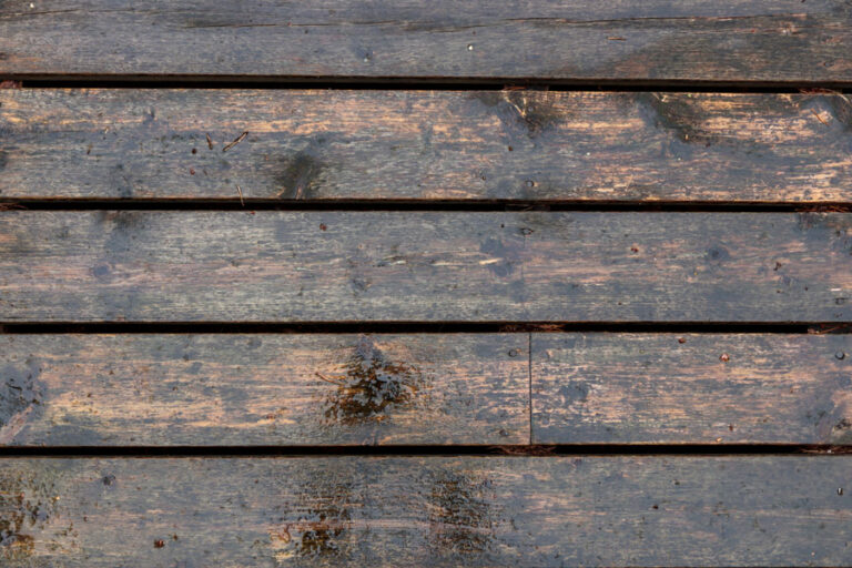 vieille terrasse en bois noircie par l'humidité vue du dessus