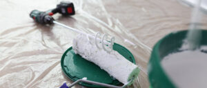brosse à rouleau mélangeur de peinture et seau avec peinture blanche sur peinture de protection de sol couvert brosse à rouleau mélangeur de peinture et seau avec peinture blanche sur peinture de protection de sol couvert