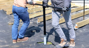 ouvriers enfoncent la vis de fondation de la terrasse avec une barre de vissage ouvriers enfoncent la vis de fondation de la terrasse avec une barre de vissage