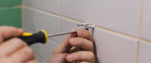 gros plan sur les mains qui utilisent le tournevis pour fixer les chevilles dans le mur gros plan sur les mains qui utilisent le tournevis pour fixer les chevilles dans le mur