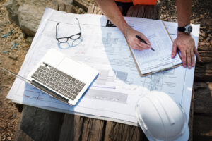ingénieur de chantier sur un chantier de construction avec ses plans et documents administratifs comme le permis de construire