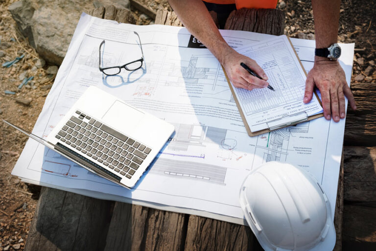 ingénieur de chantier sur un chantier de construction avec ses plans et documents administratifs comme le permis de construire
