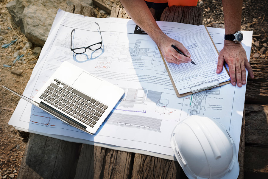 ingénieur de chantier sur un chantier de construction avec ses plans et documents administratifs comme le permis de construire