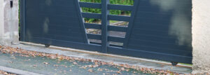 portail coulissant gris aluminium sur rails à l’entrée d’une maison de banlieue portail coulissant gris aluminium sur rails à l'entrée d'une maison de banlieue