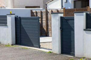 portail électrique coulissant en aluminium gris anthracite ouvert sur une maison moderne