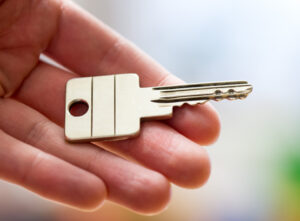 gros plan d'une clé de maison dans une main