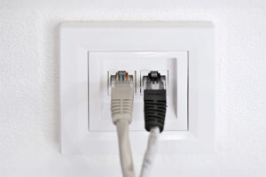 gros plan sur une prise murale RJ45 double avec deux câbles ethernet branchés dessus