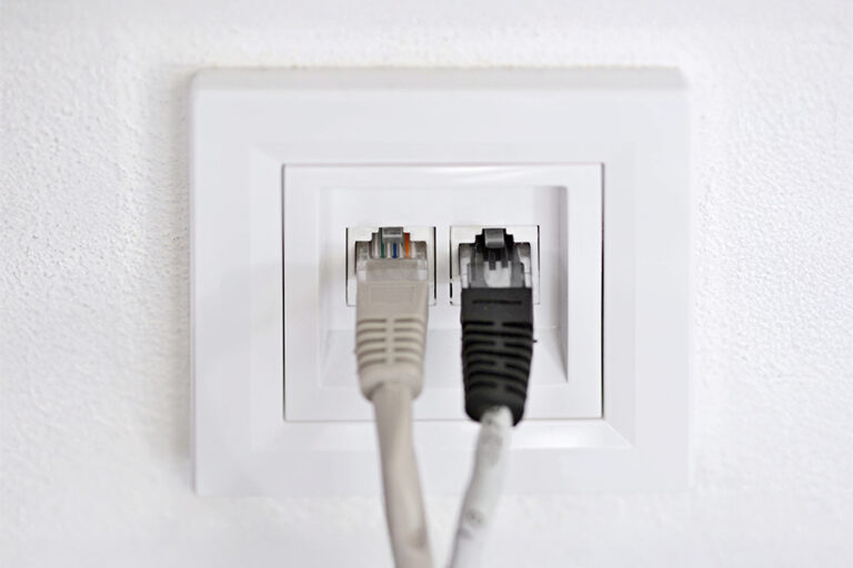 gros plan sur une prise murale RJ45 double avec deux câbles ethernet branchés dessus