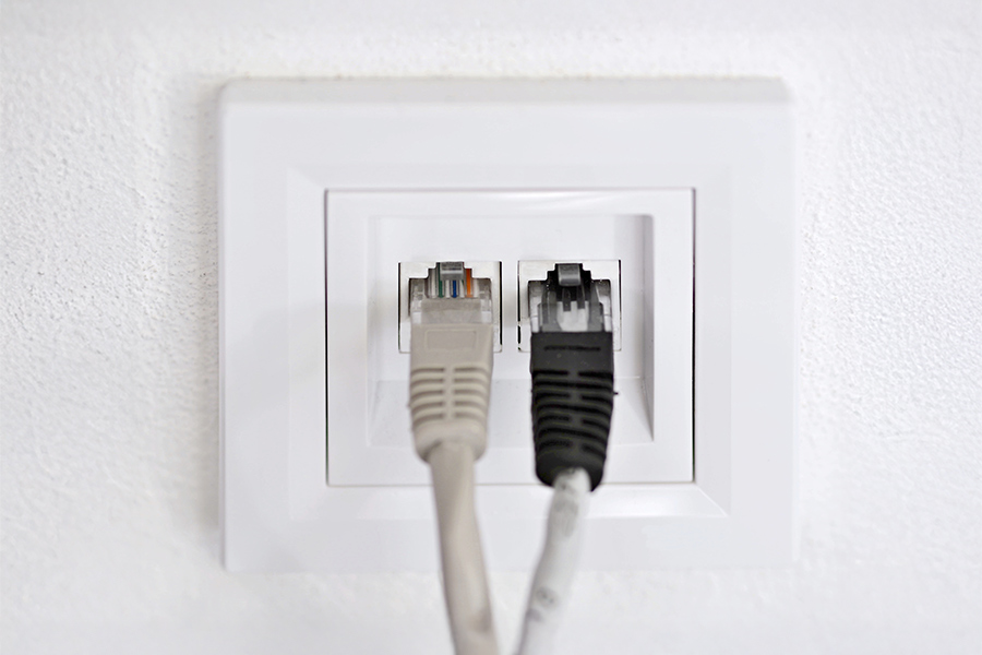 gros plan sur une prise murale RJ45 double avec deux câbles ethernet branchés dessus