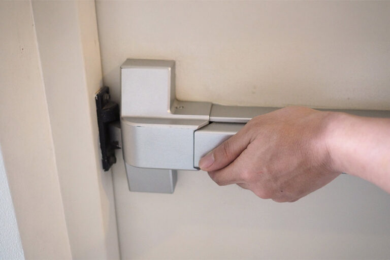 la main pousse la poignée de la porte coupe-feu de l'issue d'urgence pour l'évacuation incendie