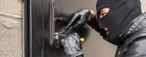 le cambrioleur est en train de crocheter la porte avec des outils