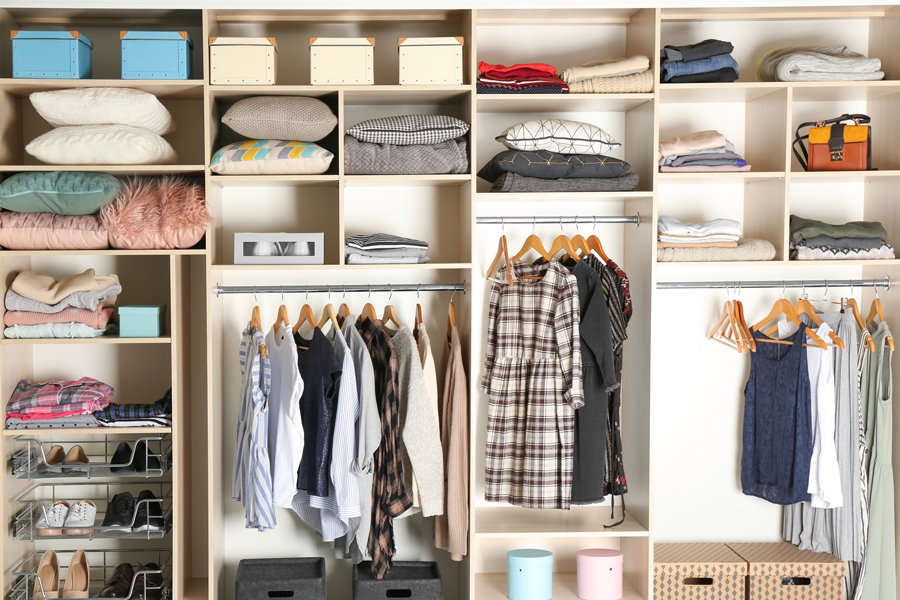 grand placard avec différentes chaussures et vêtements. organisé avec un système de rangement ergonomique et pratique pour optimiser l'espace du dressing