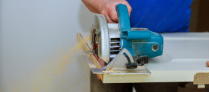 homme utilisant une scie circulaire pour couper la construction de portes en bois et la rénovation de la maison