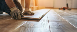 ouvrier pose la lame de parquet sur le revêtement de sol