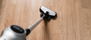 passer l'aspirateur sur le parquet pour retirer la poussière