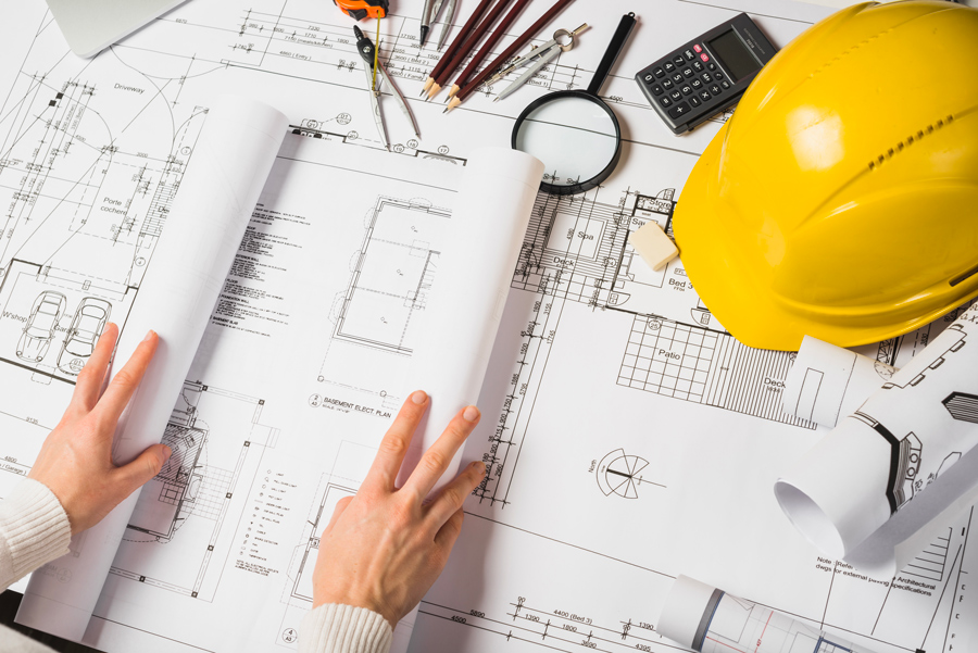 l'architecte ouvre son plan de construction de maison pour le montrer le dessin technique du projet au client