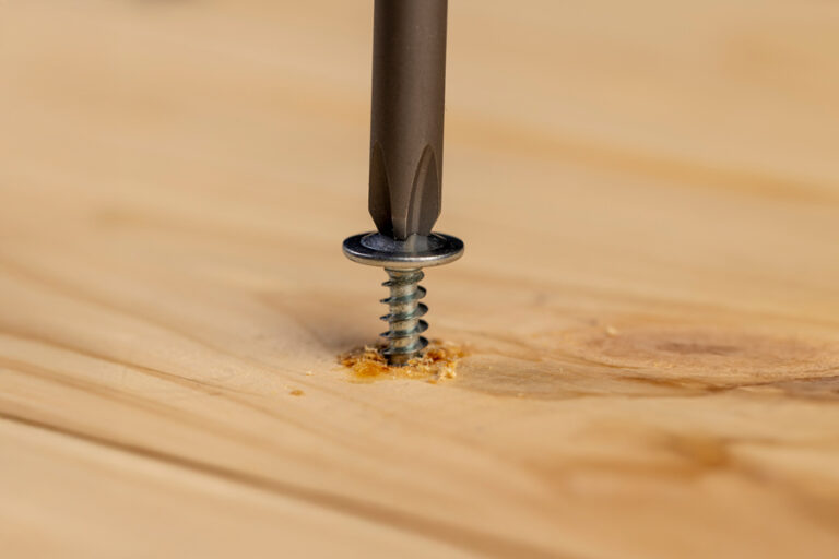 vis de bois et d'acier sur une planche de bois