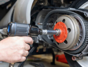 gros plan sur les mains du mécanicien qui vis un écrou avec la visseuse dynamométrique