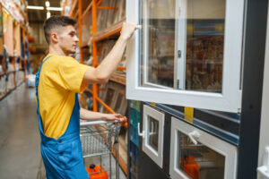 bricoleur choisit une fenêtre en pvc dans un magasin de bricolage
