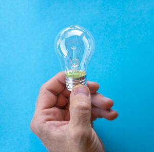 la main tient une ampoule à incandescence