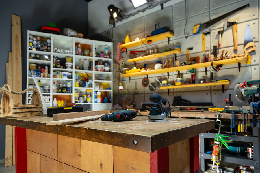 atelier de bricolage organisé avec des rangements pour le matériel et un établi pour travailler