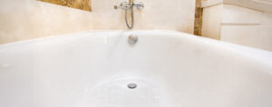 de l'eau savonneuse stagne au fond de la baignoire, elle a du mal à s'écouler après le bain à cause du siphon bouché